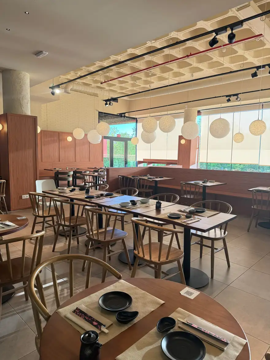 Comedor de NOOCA con mesas de madera y faroles de papel