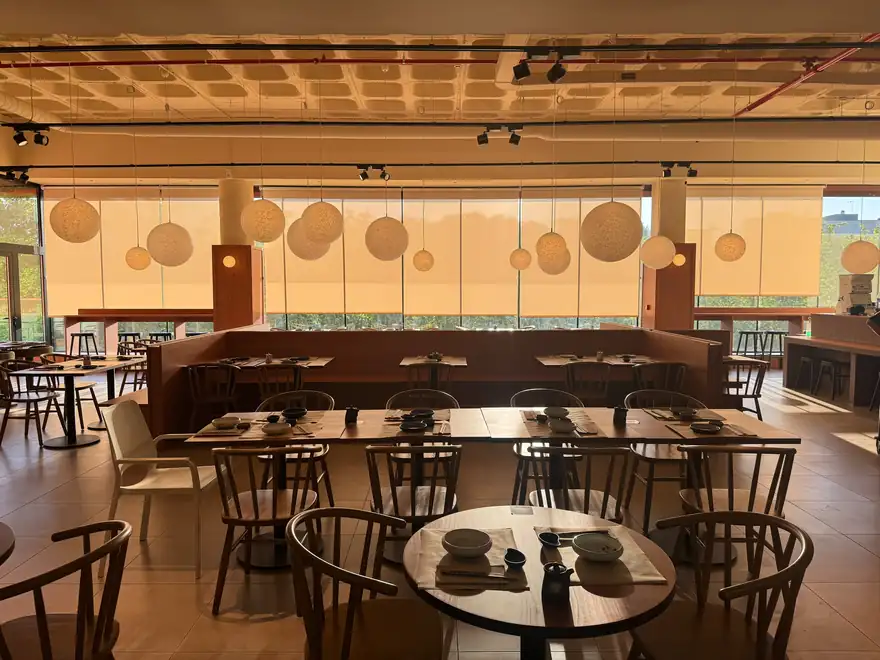 Salón amplio con ventanales y lámparas esféricas